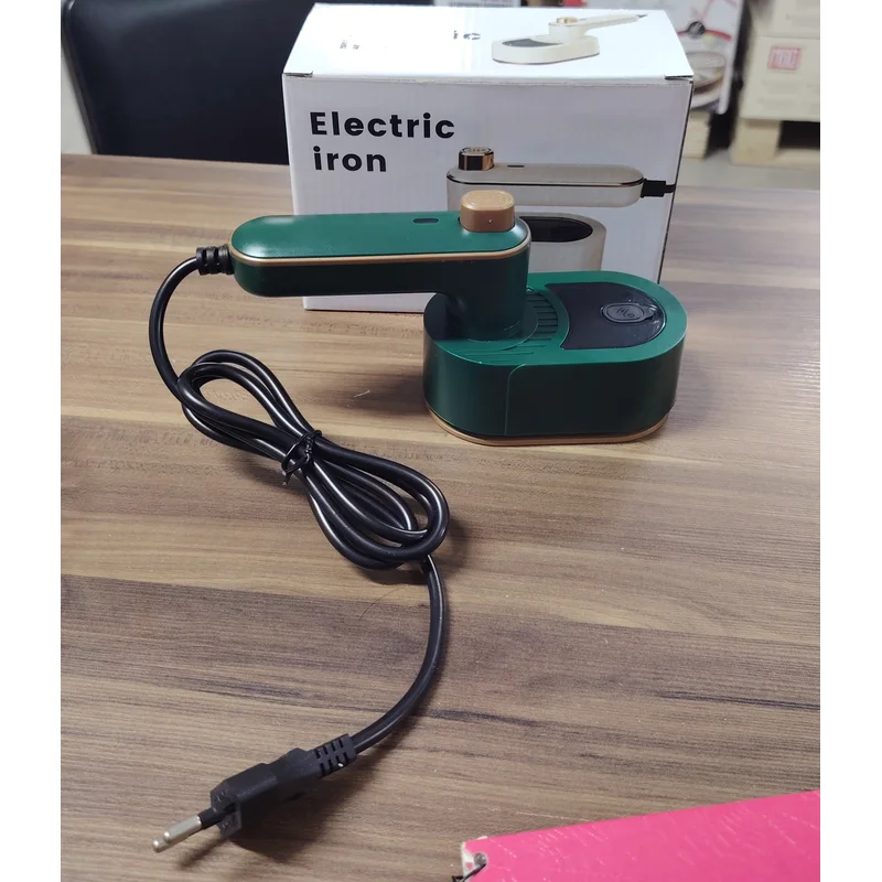 Plancha de viaje verde y compacta sobre una mesa