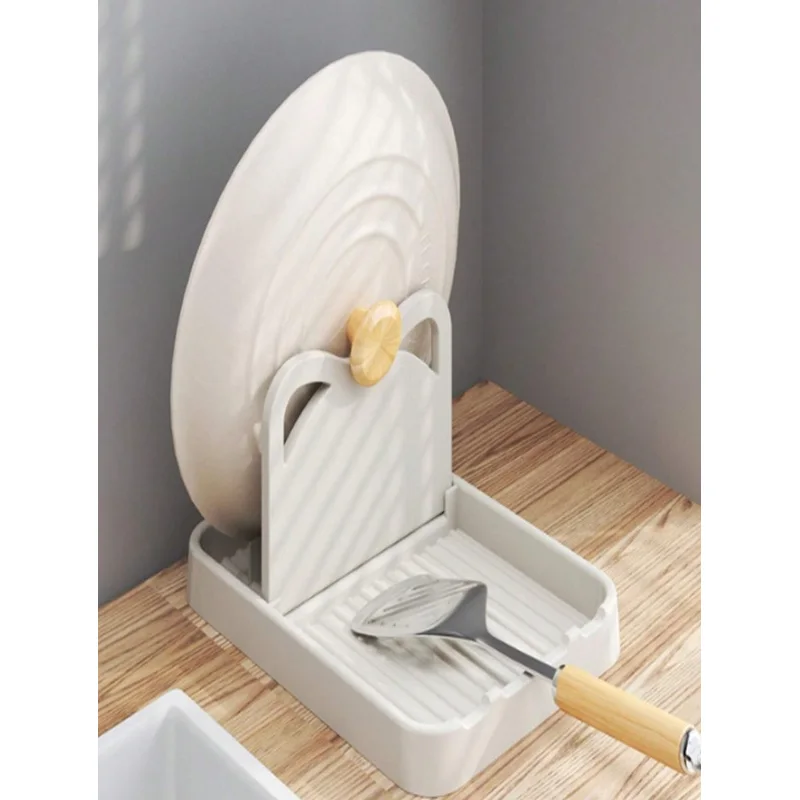 Soporte blanco con una tapa de olla y un cucharón apoyados
